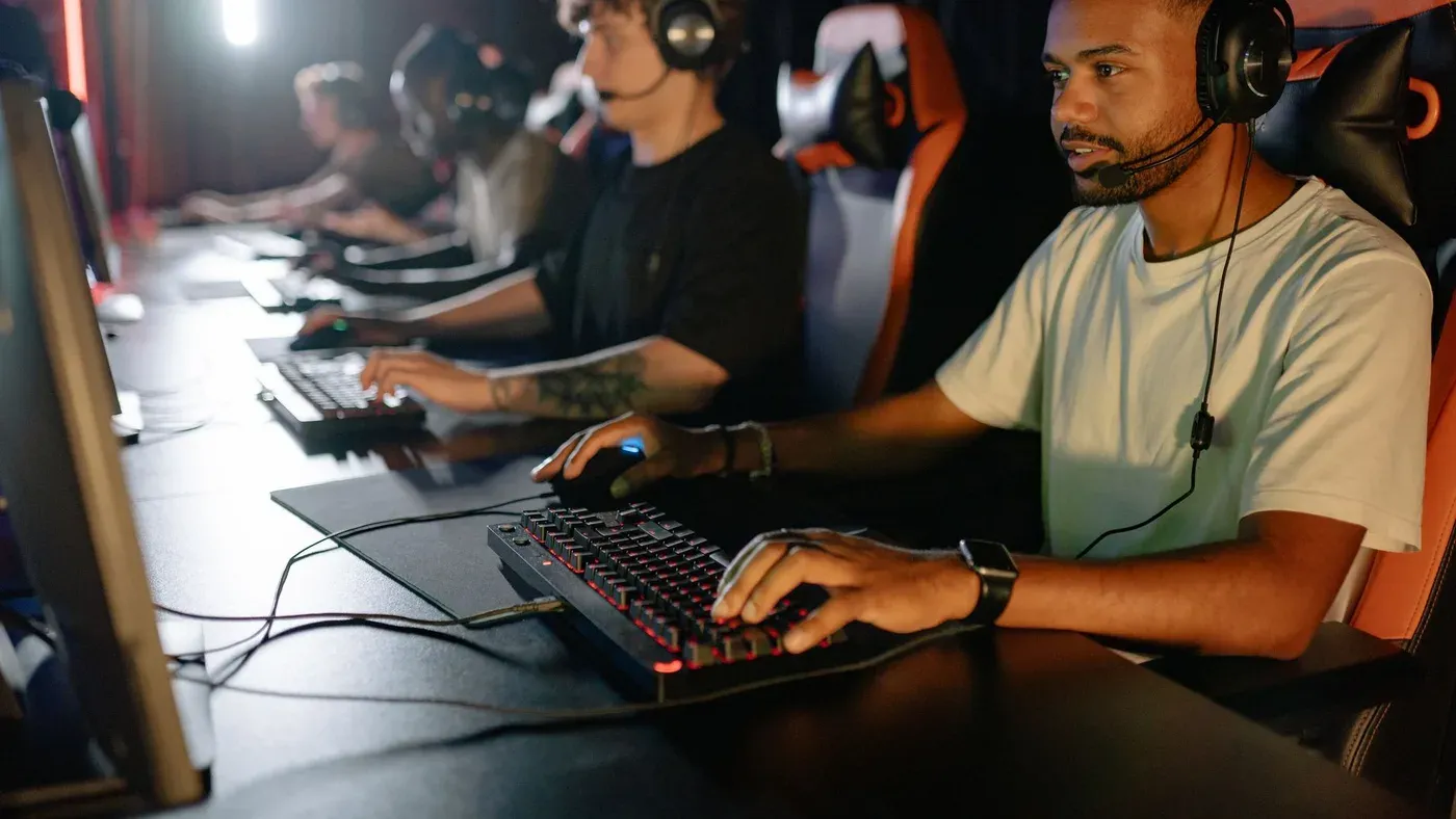 Unga spelare vid varsin dator under en e-sportsession inomhus