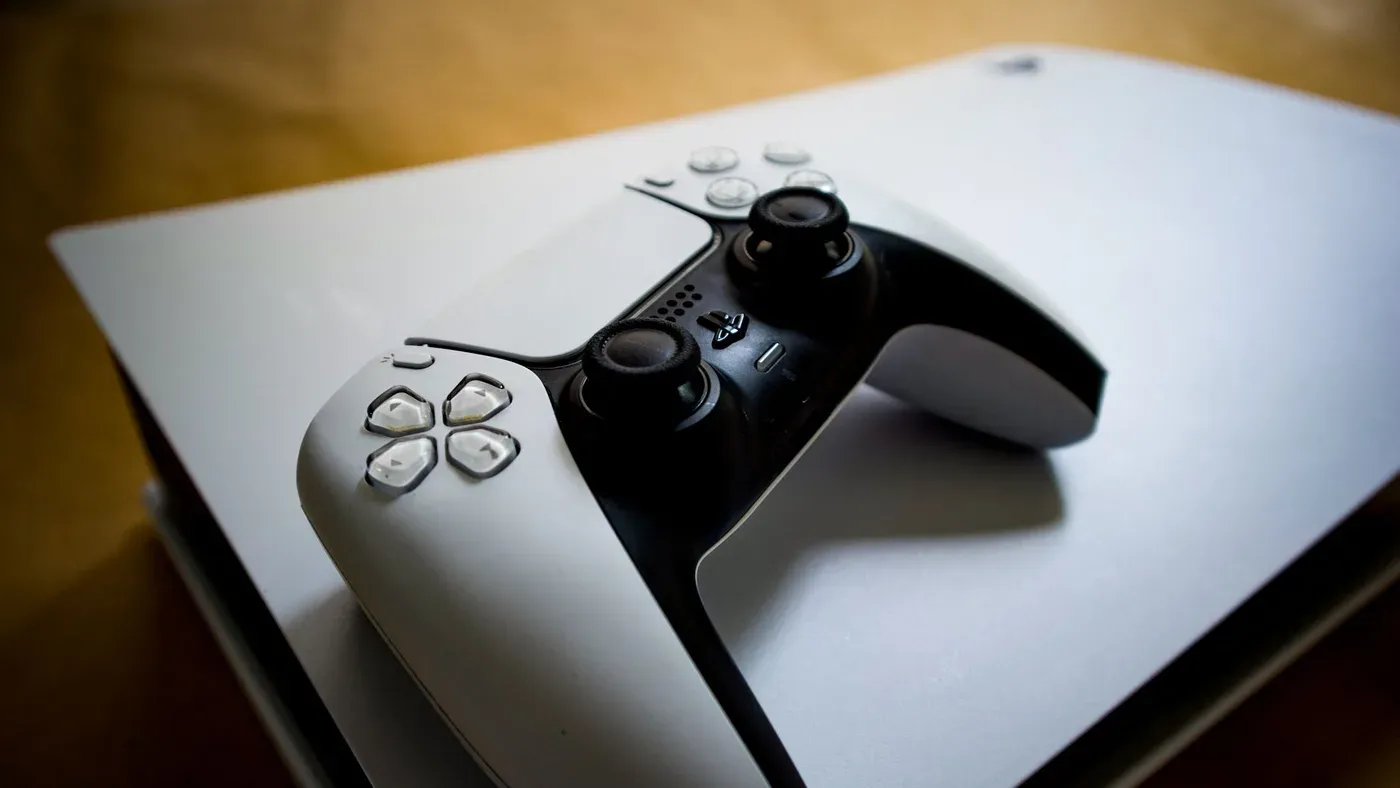 Playstation 5-handkontroll som vilar på konsolen.