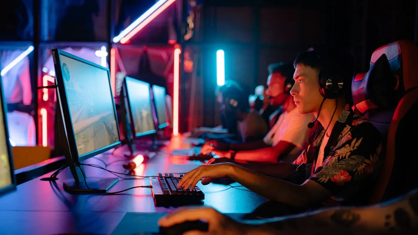 Grupp spelare i en e-sportarena med neonbelysning.