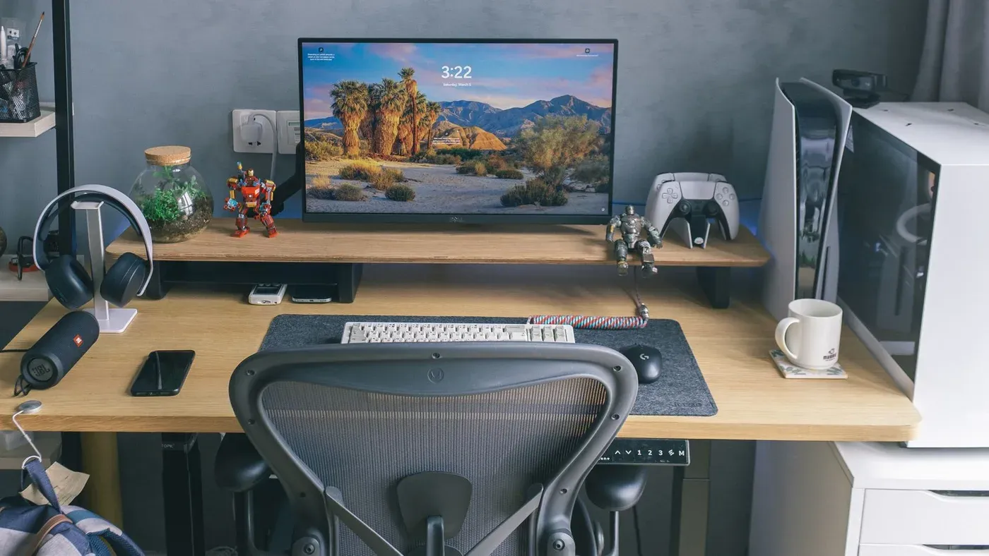 Modernt hemmakontor med datorutrustning, gamingtillbehör och inredningsdetaljer.