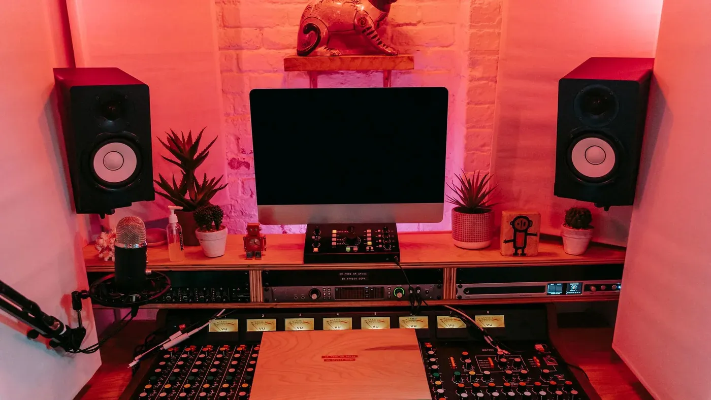 Musikstudio med mixerbord, högtalare och datorskärm.