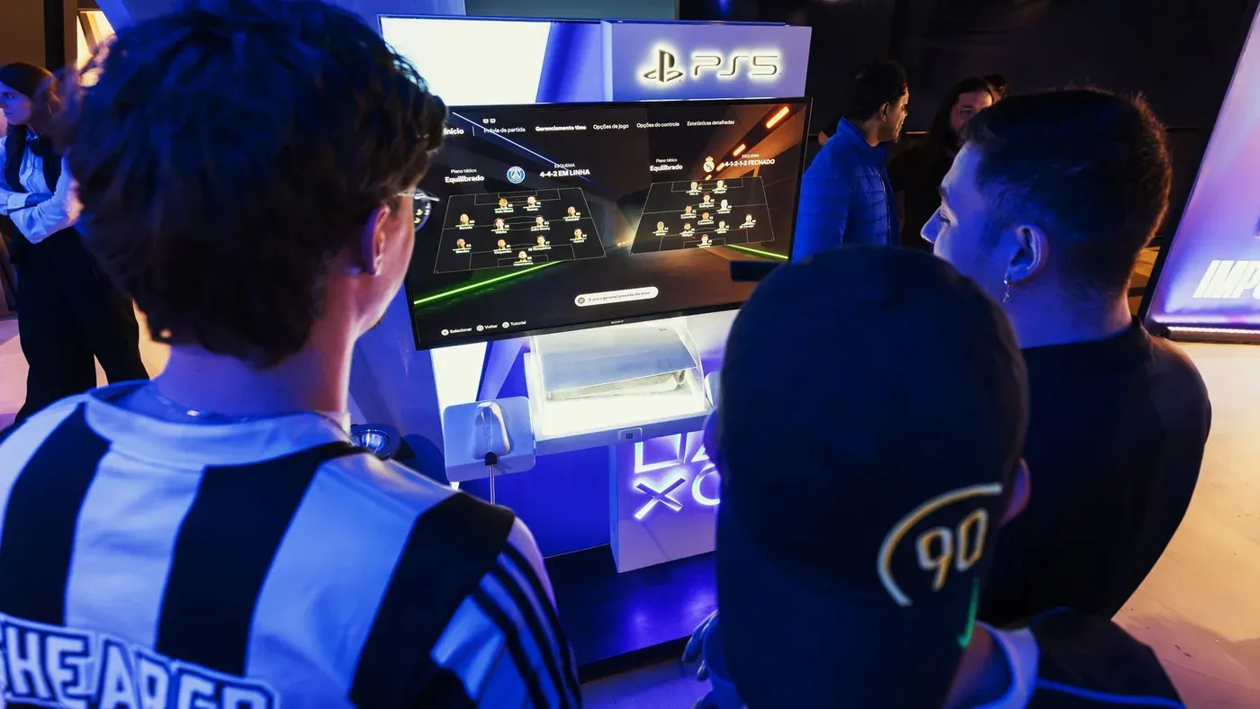Grupp spelare väljer lag på en fotbollsspelsskärm vid ett Playstation-evenemang.