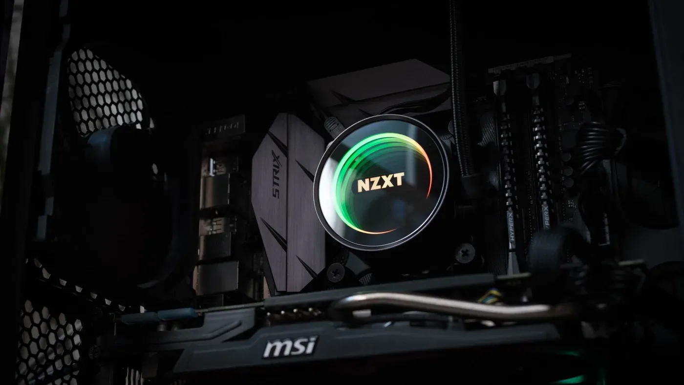 Detaljbild på en upplyst NZXT-kylare inuti en gamingdator med avancerade komponenter.